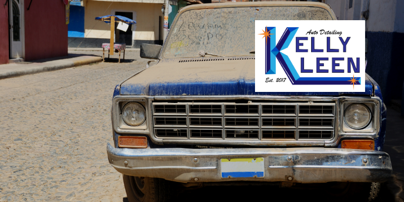 a dusty truck parked on the side of the road