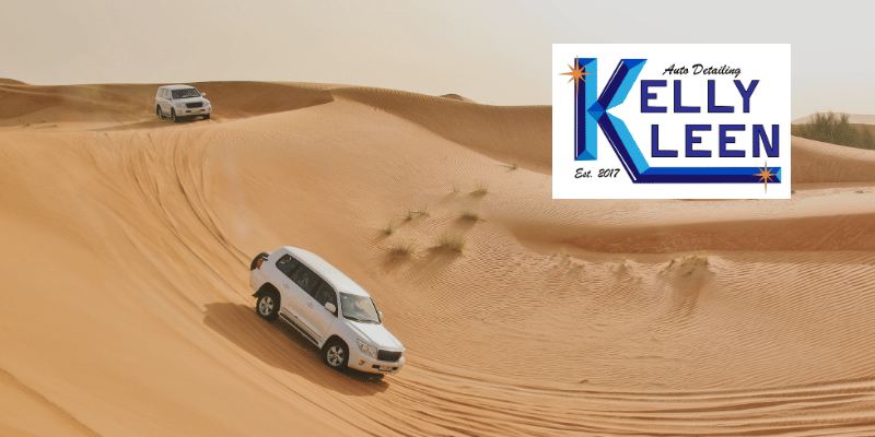 two cars driving across desert sand dunes