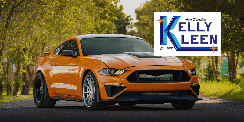 a new, orange ford mustang parked in the road