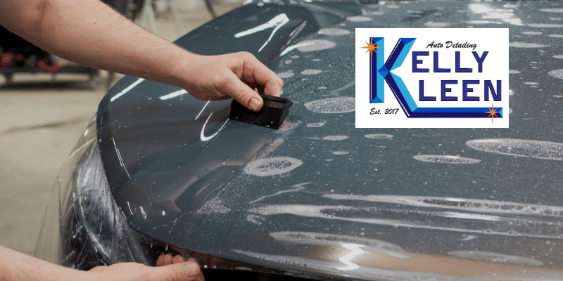 technician applying paint protection film to car